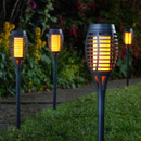 Several lit stake lights in a garden lawn Several lit stake lights in a garden lawn