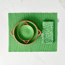 A green napkin and placemat set displayed with a green tapas dishes