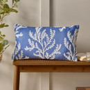 A blue and white coral design rectangle cushion on a wooden bench