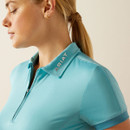 A close up of a woman wearing a blue polo top with a quarter zip