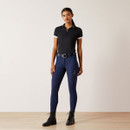 A woman standing wearing a black polo top