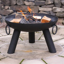A black fire pit with burning logs on a stone patio.