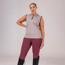 Person in a sleeveless top and maroon leggings with black boots on a white background.