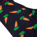 A dark sock with a pattern of orange carrots and green tops.