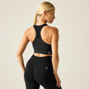 Rear view of model wearing black racerback sports bra and black leggings, showing the breathable mesh back panel.