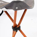 A close-up of a foldable chair's joint with orange legs and gray seat fabric.