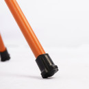 Close-up of an orange metal chair leg with a black rubber cap placed on a white surface. The setting is minimalistic, highlighting the leg's design.
