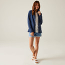 A full length view of a woman wearing a navy full zip fleece with blue shorts and white sandals.