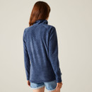 The back of a woman wearing a navy fleece with a high collar.