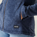 A close up view of a hand inside the fleeces side pocket.