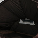 Interior of a dark-coloured tent with a partial view of the entrance flap. A sliver of light filters through, creating a serene and calm atmosphere.