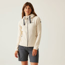 A woman wearing a cream coloured full zip fleece with navy hood adjusters.