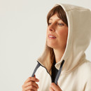 A close up view of the fleeces cream coloured hood and navy adjusters.