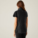 The back of a woman wearing a black quilted gilet over a short-sleeved t-shirt.