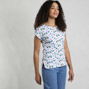 A person stands in a floral-patterned shirt and denim jeans against a textured neutral background, showcasing a casual summer outfit. A person stands in a floral-patterned shirt and denim jeans against a textured neutral background, showcasing a casual summer outfit.
