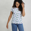A person is wearing a floral-patterned t-shirt with colourful flowers against a light background, paired with blue jeans. A person is wearing a floral-patterned t-shirt with colourful flowers against a light background, paired with blue jeans.
