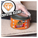 Hand opening a can of Gorilla Contact Adhesive labelled "Crystal Clear" on a work surface.
