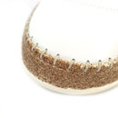 Rear view of white leather lace-up trainer showing heel seam and cork-effect midsole on a white background.