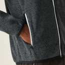 A close up view of a person's hand in one of the fleeces side pockets.