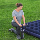 A view of someone using a black hammer air hammer on on green grass