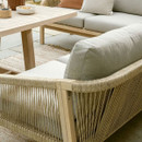 A close up view of the corner sofa's rope detailing on the arms and pale cushions, with the wooden table in the background.
