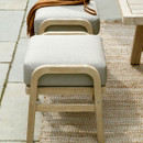 A close up view of the two wooden footstools with pale cushions.