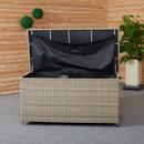 Open wicker storage box with black interior lining on a carpeted floor. Wooden wall and green potted plant create a cosy, organized space.