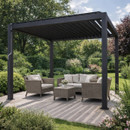 Dark grey metal pergola in a landscaped garden with a small wicker outdoor seating set underneath, including two armchairs, a loveseat, and a coffee table on a stone patio, surrounded by lush greenery.