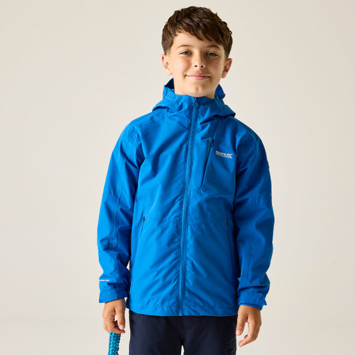 A smiling child wearing a bright blue rain jacket stands against a plain background, holding a blue rope. The mood is cheerful and playful.