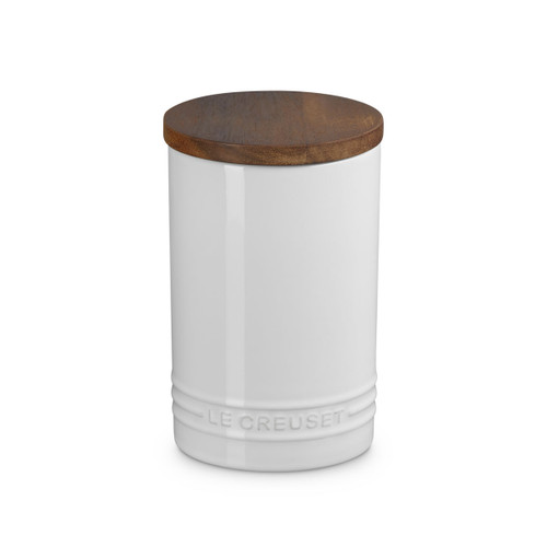 A white storage jar with a wooden lid.