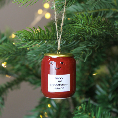 A view of a ceramic jar of cranberry sauce hanging decoration hanging on a Christmas tree