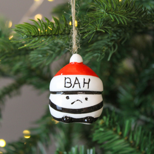 A view of a ceramic bah humbug hanging decorations hanging on a Christmas tree