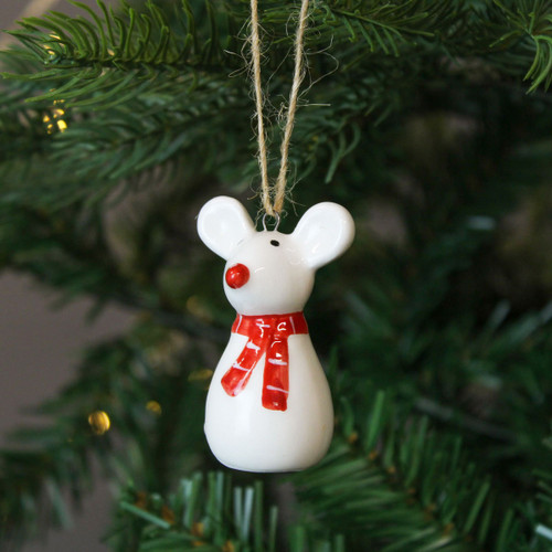 A view of a ceramic white mouse hanging decoration hanging on a Christmas tree