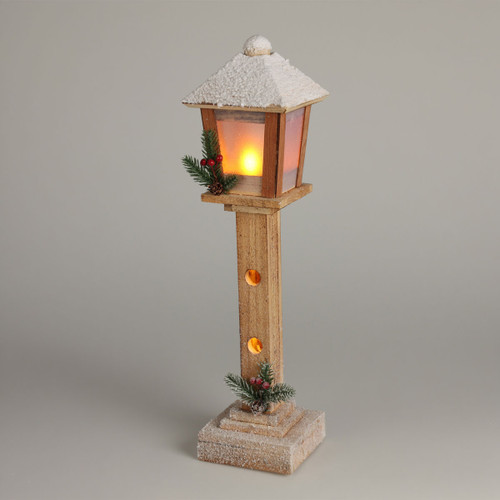 Rustic wooden Christmas lantern with warm LED light, snow-covered roof and festive pinecone, berry and evergreen accents, ideal for seasonal home décor.