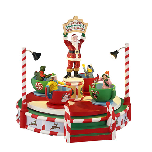 A whimsical Christmas-themed tea cup ride featuring Santa and colorful characters in festive cups, surrounded by striped poles and lights.