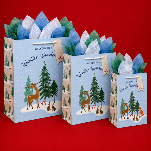 Three winter woodland Christmas gift bags in assorted sizes, featuring deer, rabbits and foxes among snowy fir trees.