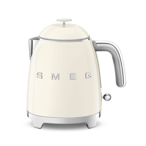 A cream mini SMEG kettle with silver accents.
