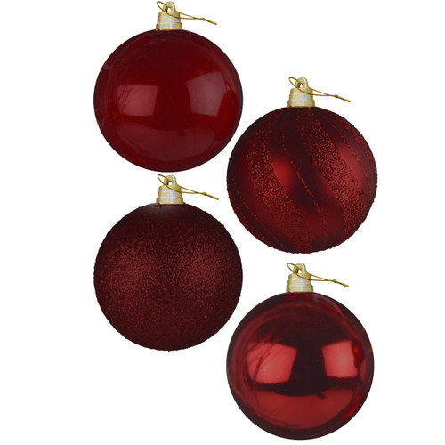 Four festive red Christmas ornaments with different textures: glossy, glittery, and striped, all adorned with golden hooks.