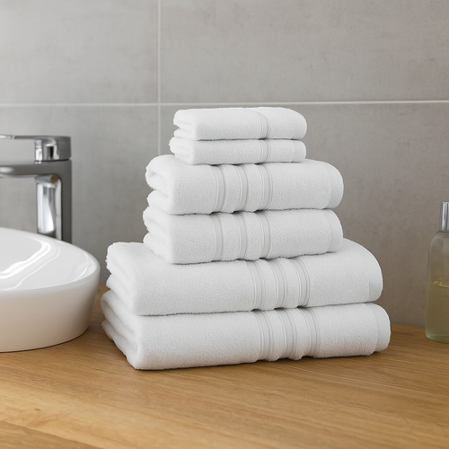 A view of all the Catherine Lansfield Zero Twist Cotton Towels in white stacked on a counter top
