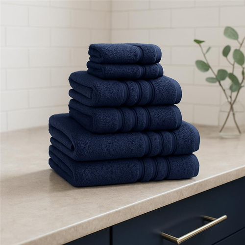 A view of all the Catherine Lansfield Zero Twist Cotton Towels in navy stacked on a counter top