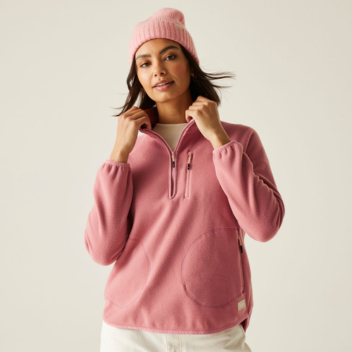 A woman wearing a dusty rose pink coloured half zip fleece.