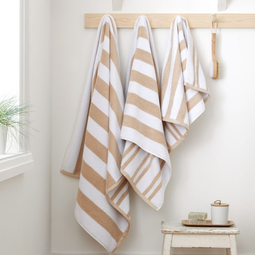 A view of natural striped Bianca Fine Linens hand towel, bath towel, bath sheet hung on hooks A view of natural striped Bianca Fine Linens hand towel, bath towel, bath sheet hung on hooks