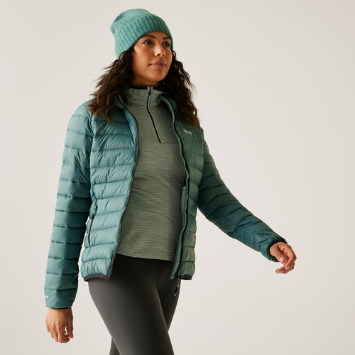 A woman wearing a green quilted jacket with a hood.