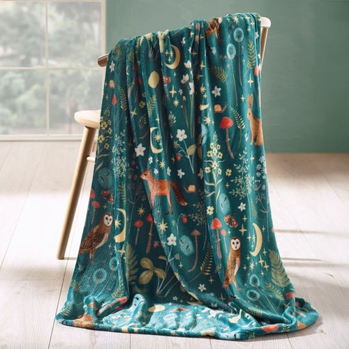 A view of a green Catherine Lansfield Enchanted Twilight throw blanket on a chair