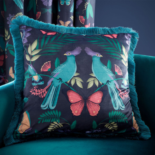 A view of a vibrant navy and teal fringed Catherine Lansfiled Mya cushion on a chair