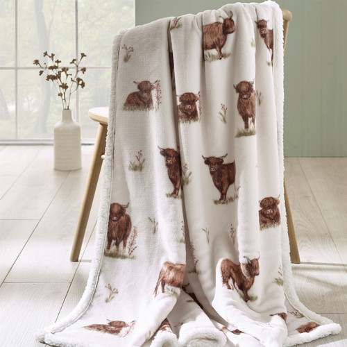 A view of a natural Catherine Lansfield Highland cow throw on a chair