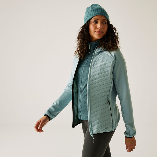 A woman wearing a light green padded jacket with a hood.