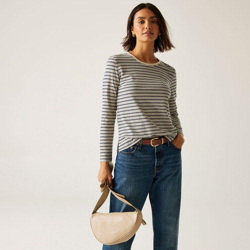 A woman wearing a long sleeved, vanilla and navy coloured, striped top.