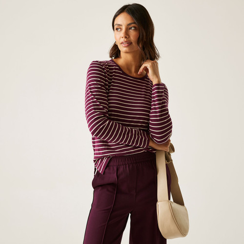 A woman wearing a long sleeved, red striped top.