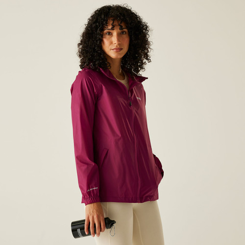 A woman wearing a pink waterproof jacket with a hood.